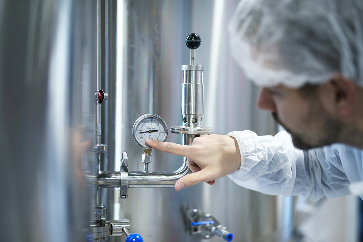 technologist-white-protective-suit-checking-pressure-pressure-gauge-industrial-machine-factory